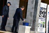 Fotografia kolorowa przedstawiająca ministra wmurowującego  kamień węgielny pod siedzibę nowego posterunku policji.