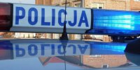 Fotografia kolorowa przedstawiająca napis policja umiejscowiony na radiowozie policyjnym