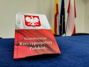 Konstytucja Rzeczpospolitej Polskiej ustawiona na granatowej tkaninie