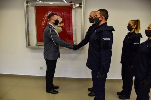 Komendant Miejski Policji w Białymstoku gratuluje poprzez uścisk dłoni  policjantowi
