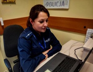 Policjantka, bruneta siedząca przed komputerem